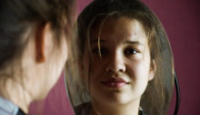 Girl smiling in a mirror.