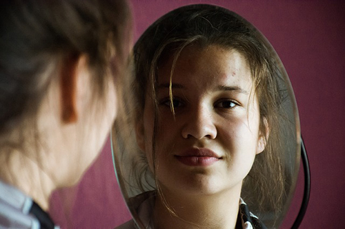 Girl smiling in a mirror.